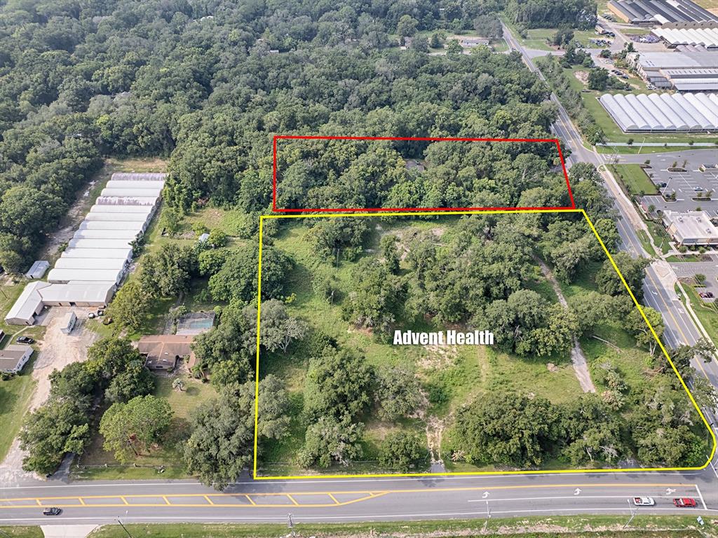 An aerial view shows two adjacent plots of land with trees and grass near a road — 4905 PLYMOUTH SORRENTO ROAD, APOPKA, FL