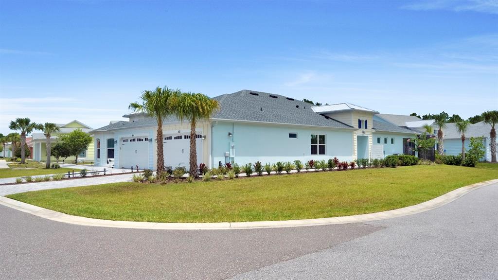 A light blue single-story house with a gray shingled roof and palm trees — 202 SUMMERTIME PLACE, DAYTONA BEACH, FL