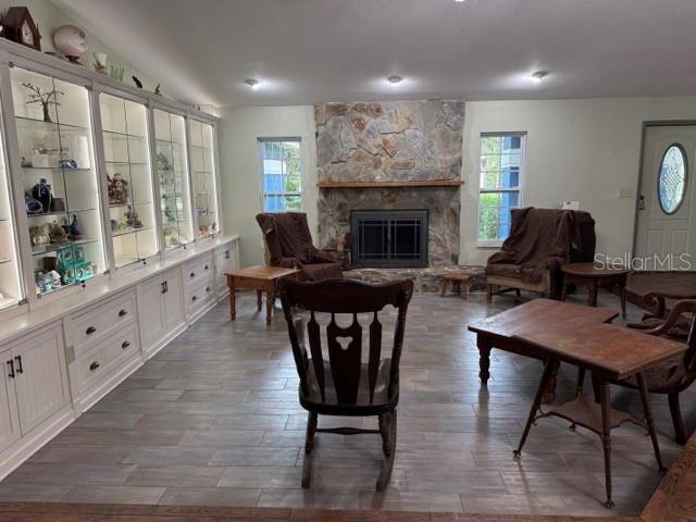 A living room features a stone fireplace, built-in display cabinets, and wood-look tile flooring — 1121 OLD POLK CITY ROAD, LAKELAND, FL
