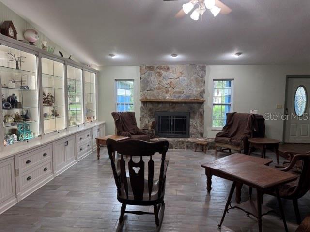 A living room features a stone fireplace, built-in glass display cabinets, and tile flooring — 1121 OLD POLK CITY ROAD, LAKELAND, FL