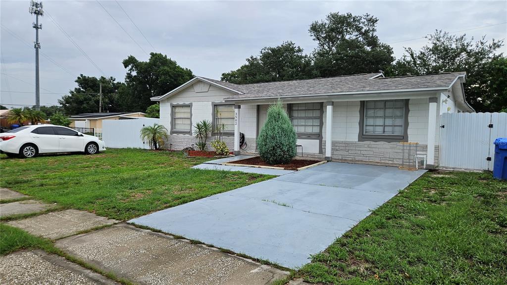 A single-story house with a white facade, gray stone base, and a concrete driveway — 3502 LIBBY LOOP, TAMPA, FL