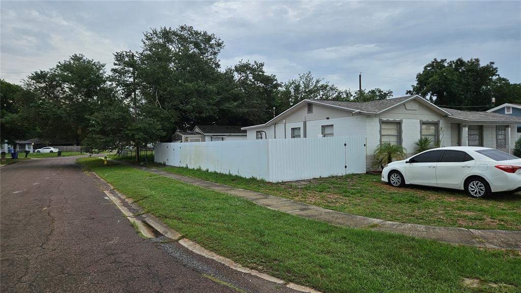 A white vinyl fence encloses the side yard of a white house with a car — 3502 LIBBY LOOP, TAMPA, FL
