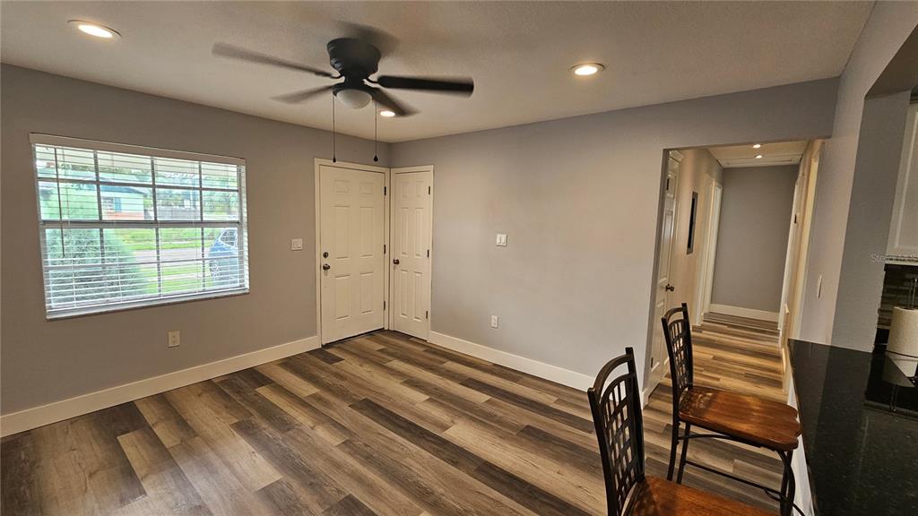 A dining area with wood-look flooring, a ceiling fan, and a view of the outdoors — 3502 LIBBY LOOP, TAMPA, FL