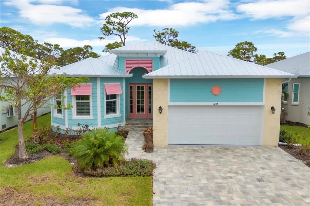 A single-story house with turquoise siding, pink accents, and a metal roof — 8936 SCALLOP WAY, PLACIDA, FL