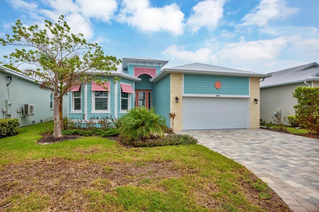 A teal, single-story house with a white garage, pink shutters, and a paved driveway — 8936 SCALLOP WAY, PLACIDA, FL