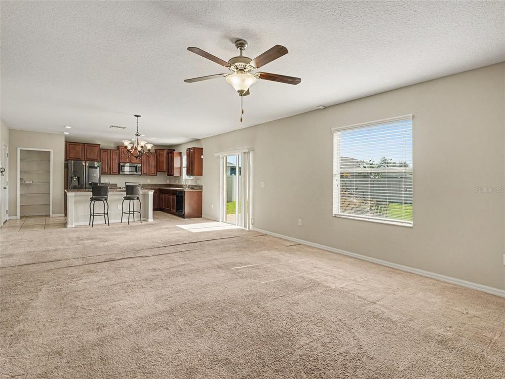A kitchen with brown cabinets, granite countertops, stainless steel appliances, and a breakfast bar — 2210 PURPLE ORCHID PLACE, RUSKIN, FL