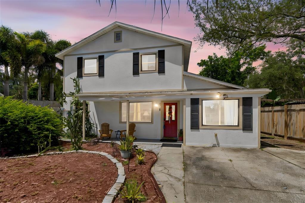 A two-story house with a white exterior, red front door, and a concrete driveway — 2017 S VILLAGE AVENUE, TAMPA, FL