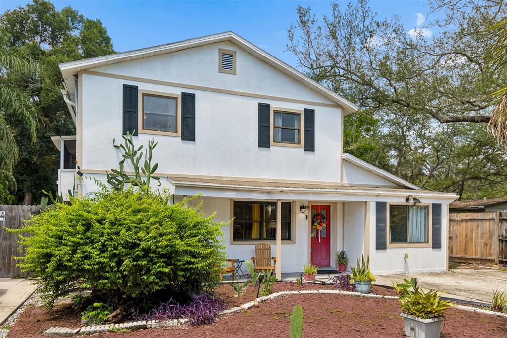 A two-story house with white stucco walls, black shutters, and a red front door — 2017 S VILLAGE AVENUE, TAMPA, FL