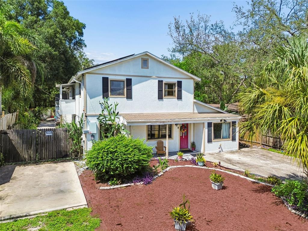 A two-story house with a white stucco exterior, black shutters, and a red front door — 2017 S VILLAGE AVENUE, TAMPA, FL