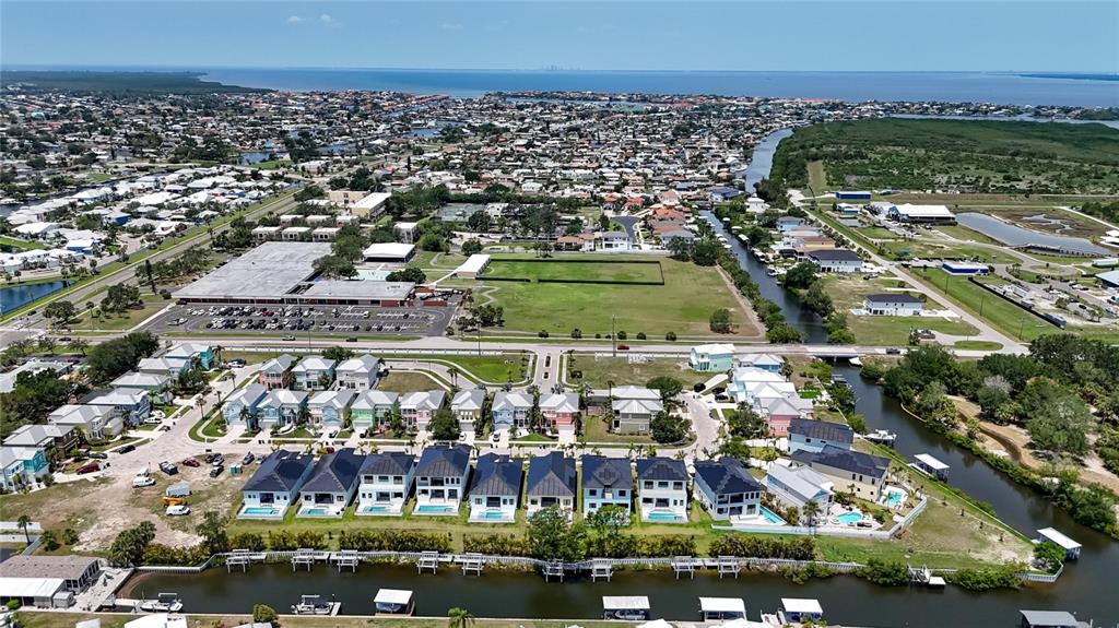 An aerial view shows a waterfront residential neighborhood with houses, boat docks, and a canal — 6530 SIMONE SHORES CIRCLE, APOLLO BEACH, FL