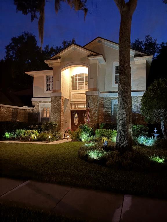 A two-story house with a brick and stucco facade, a two-car garage, and a lawn — 8052 LAUREL RIDGE DRIVE, MOUNT DORA, FL