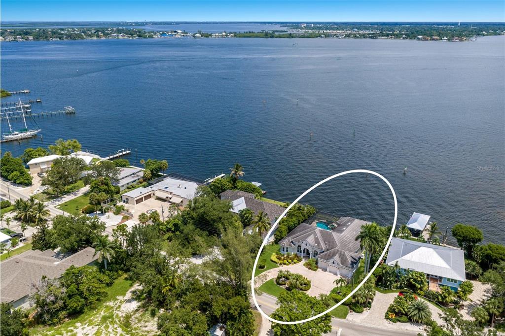 An aerial view shows a waterfront house with a pool and a circular driveway — 5904 RIVERVIEW BOULEVARD, BRADENTON, FL