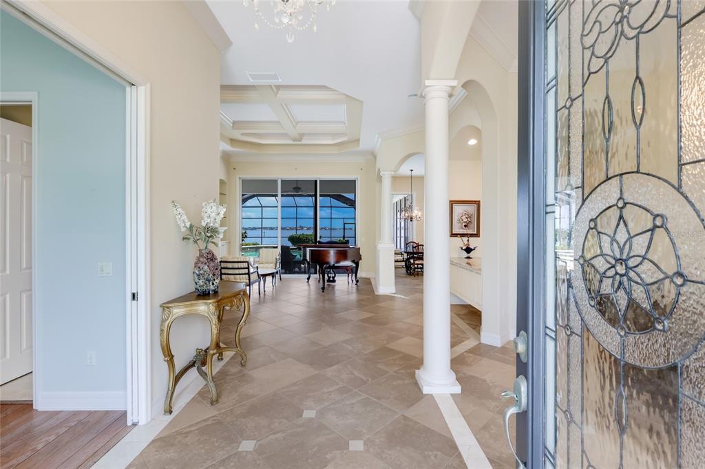 A tiled foyer leads into a living area with a grand piano and water views — 5904 RIVERVIEW BOULEVARD, BRADENTON, FL