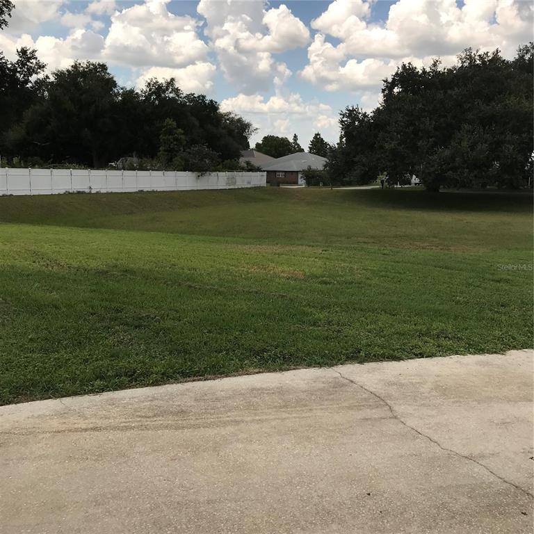 A side yard features a gravel path, a garden hose, and an air conditioning unit — 707 HARDY WAY, AUBURNDALE, FL