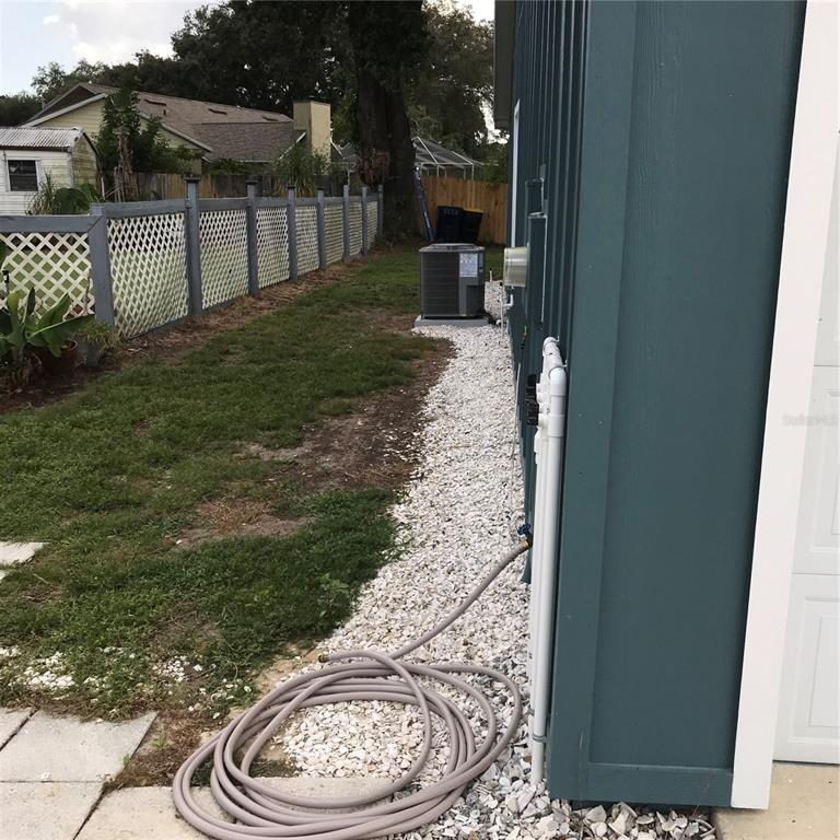 A covered porch features a gray concrete floor, white support columns, and dark blue siding — 707 HARDY WAY, AUBURNDALE, FL