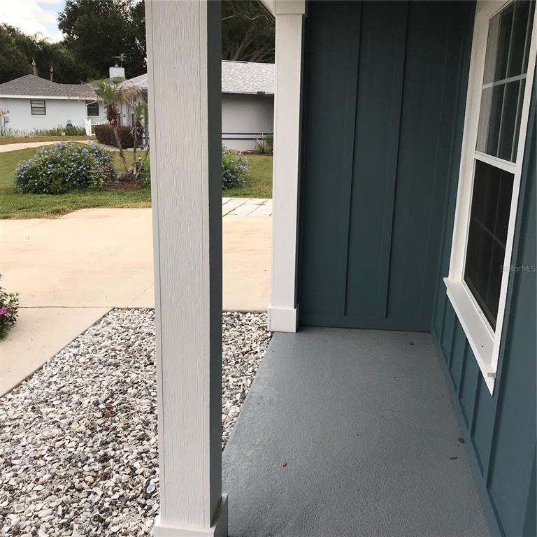 A view from a porch looking out over a white gravel garden bed and lawn — 707 HARDY WAY, AUBURNDALE, FL