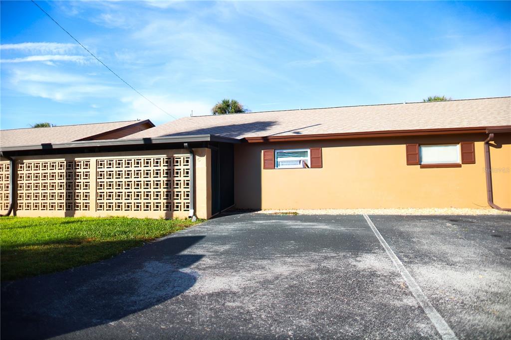 A single-story building exterior features a decorative concrete block screen wall and asphalt parking — 474 C STREET, CASSELBERRY, FL