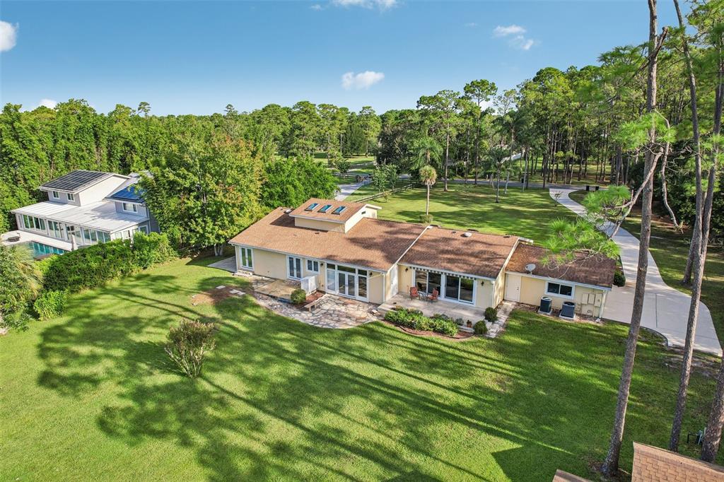 An aerial view of a single-story house with a stone patio and a large lawn — 11450 FANGORN ROAD, ORLANDO, FL