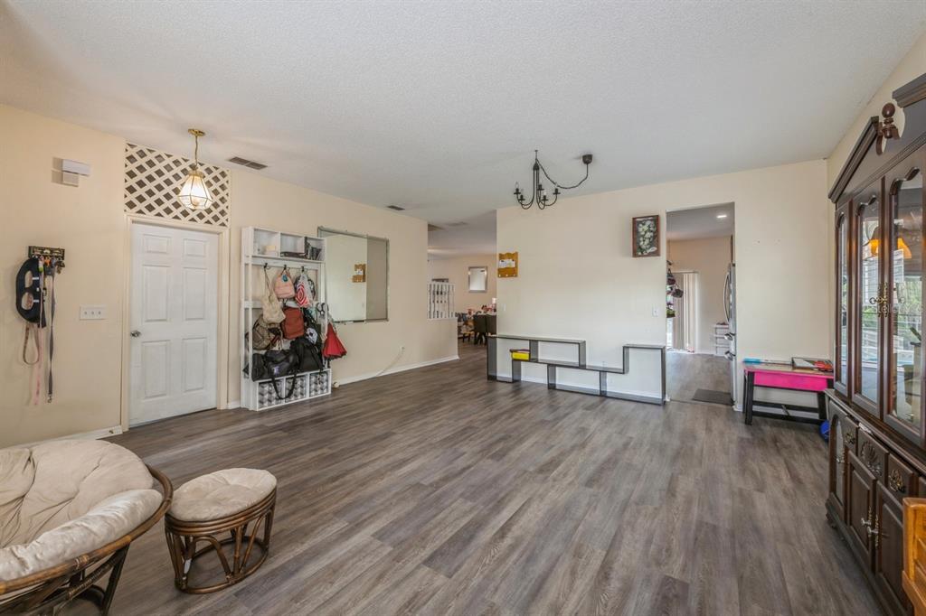 A living room with wood-look flooring, a white storage unit, and a large china cabinet — 502 FREEMAN STREET, LONGWOOD, FL