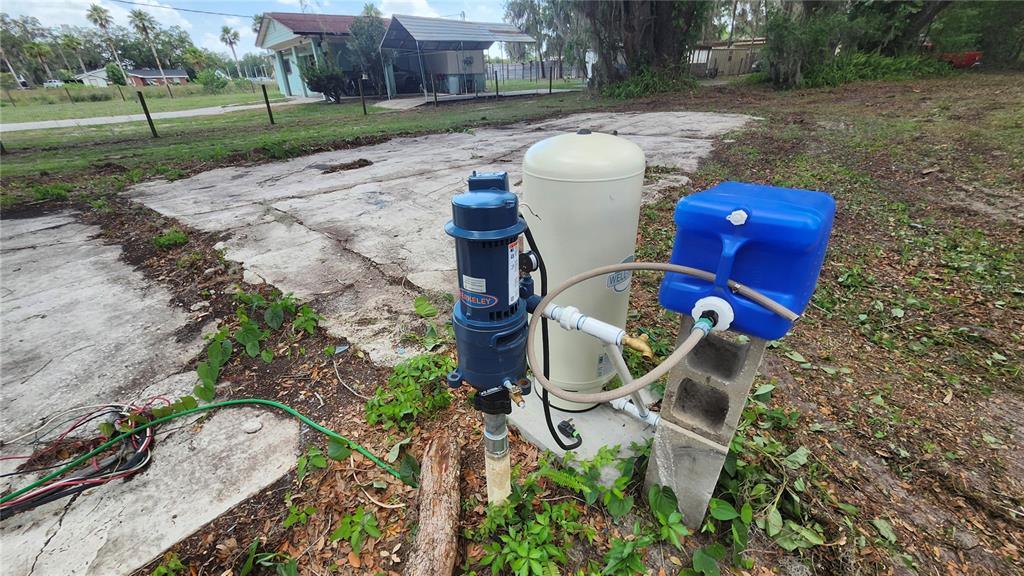 A water well pump and pressure tank sit on a concrete slab outdoors — 7059 SE COUNTY HIGHWAY 25A, BELLEVIEW, FL