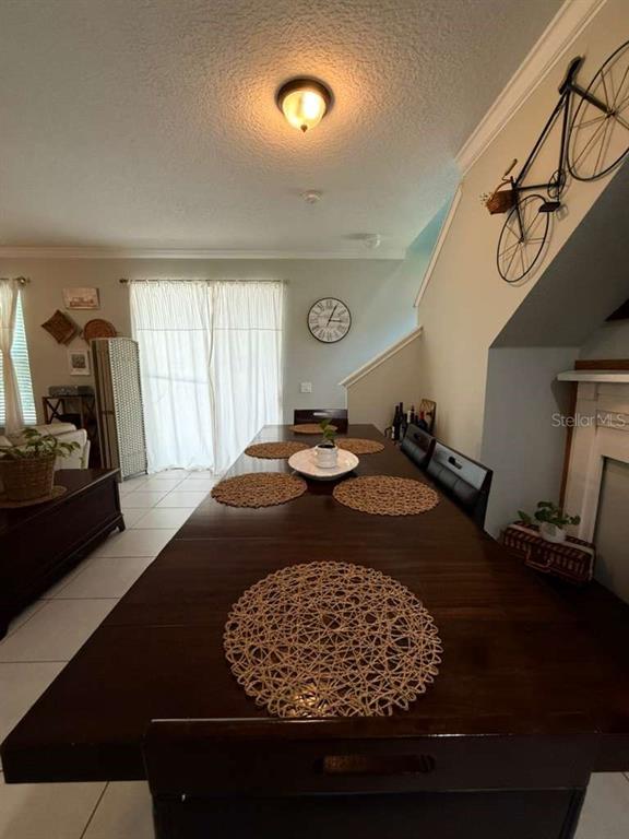 A dining room features a long wooden table with woven placemats and a wall-mounted bicycle — 4800 POOLSIDE DRIVE, ST CLOUD, FL