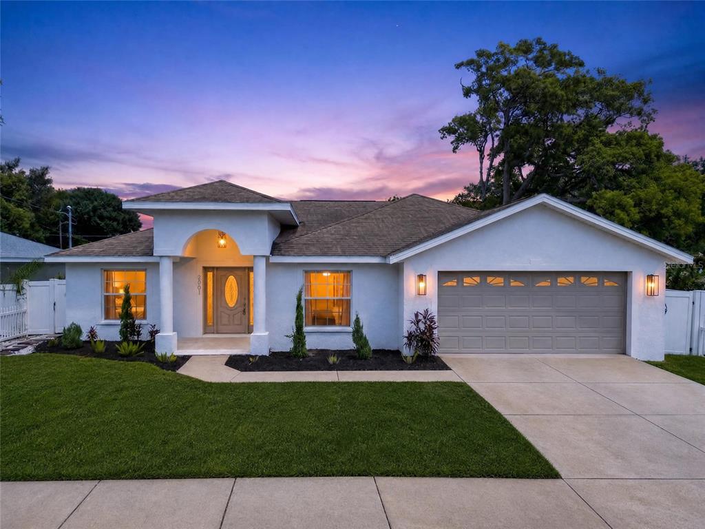 A single-story house with a white stucco exterior, a two-car garage, and a front entryway — 2001 N LINCOLN AVENUE, TAMPA, FL