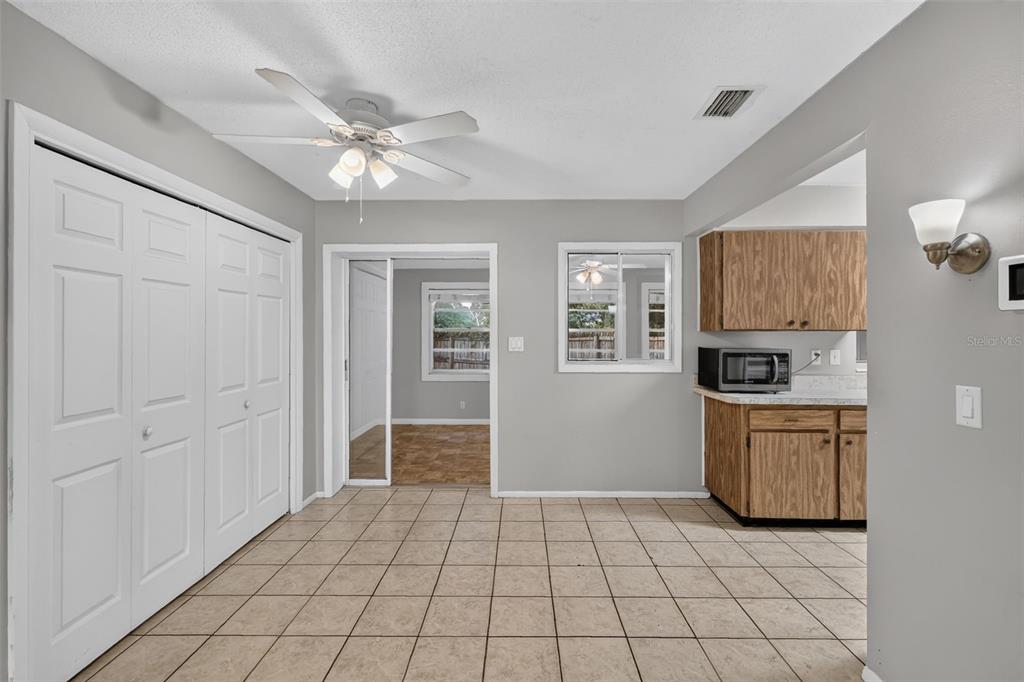A dining area with tiled floors, a ceiling fan, and a view into an adjacent room — 1305 ORANGE AVENUE, TAVARES, FL