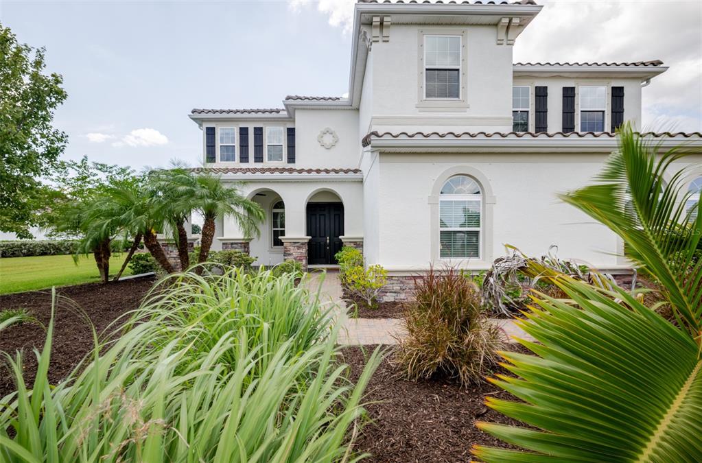 A two-story white stucco house with a black front door and arched windows — 4789 VASCA DRIVE, SARASOTA, FL