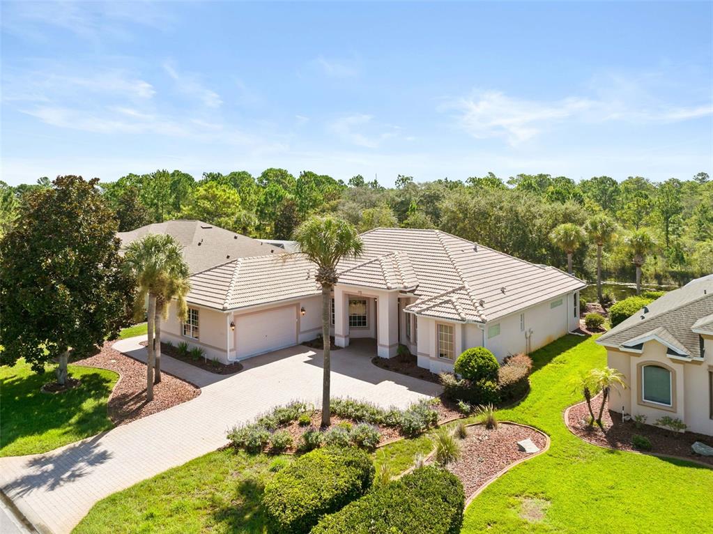 An aerial view of a single-story house with a tiled roof and paved driveway — 9250 MISSISSIPPI RUN, WEEKI WACHEE, FL