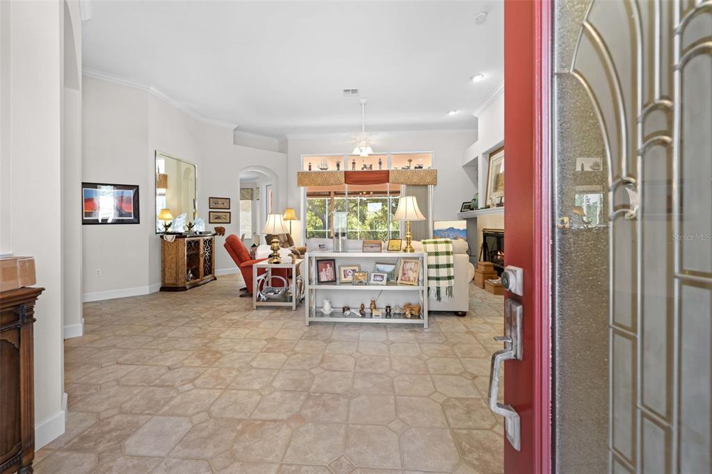 A view from a doorway into a living room with tile floors and a fireplace — 9250 MISSISSIPPI RUN, WEEKI WACHEE, FL