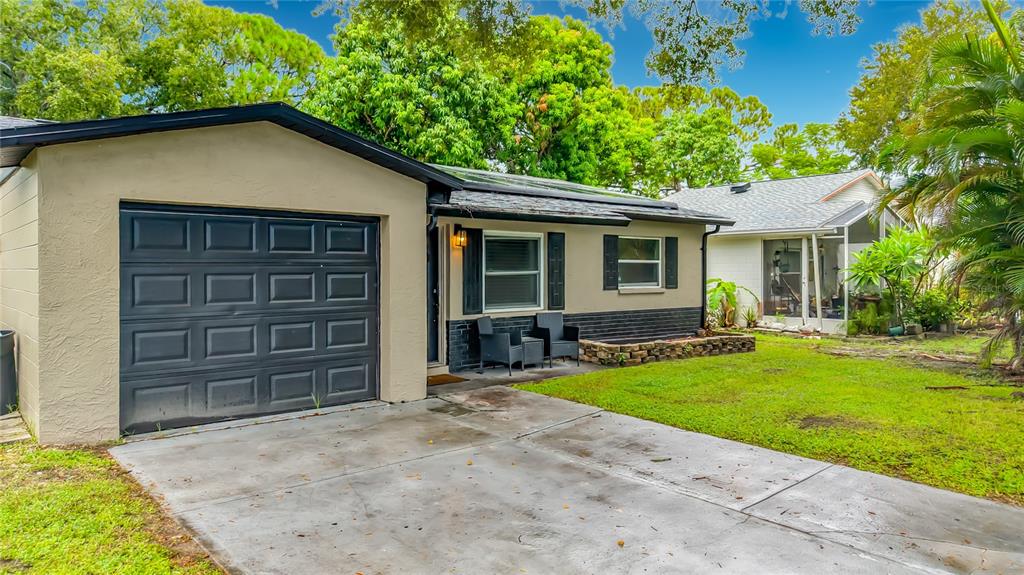 A single-story house with a garage, a concrete driveway, and a small front patio area — 8320 43RD WAY N, PINELLAS PARK, FL