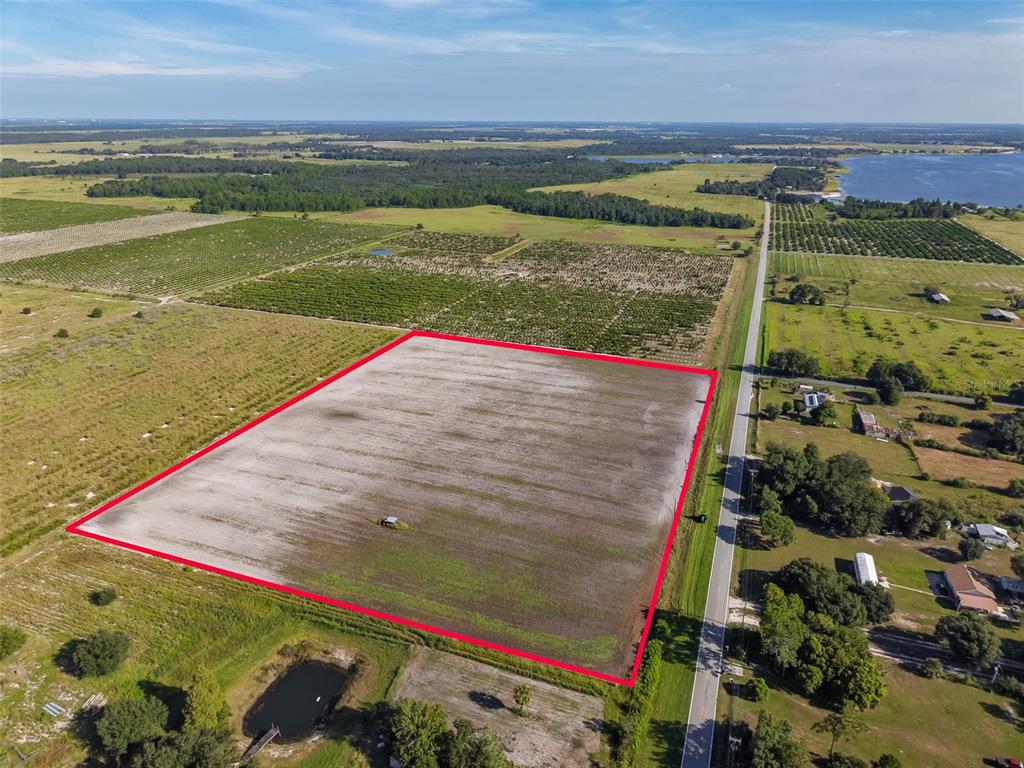 An aerial view shows a large, rectangular cleared field outlined in red next to a road — DOC LINDSEY ROAD, FORT MEADE, FL