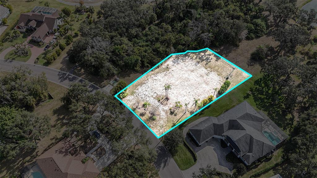 An aerial view shows a vacant, cleared residential lot outlined in blue within a neighborhood — 3001 WILDERNESS BOULEVARD E, PARRISH, FL