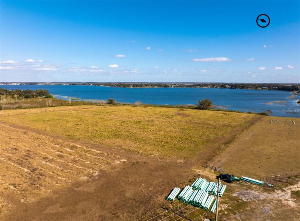 An aerial view shows a large, grassy vacant lot bordering a wide lake — OLD BERKLEY ROAD, AUBURNDALE, FL