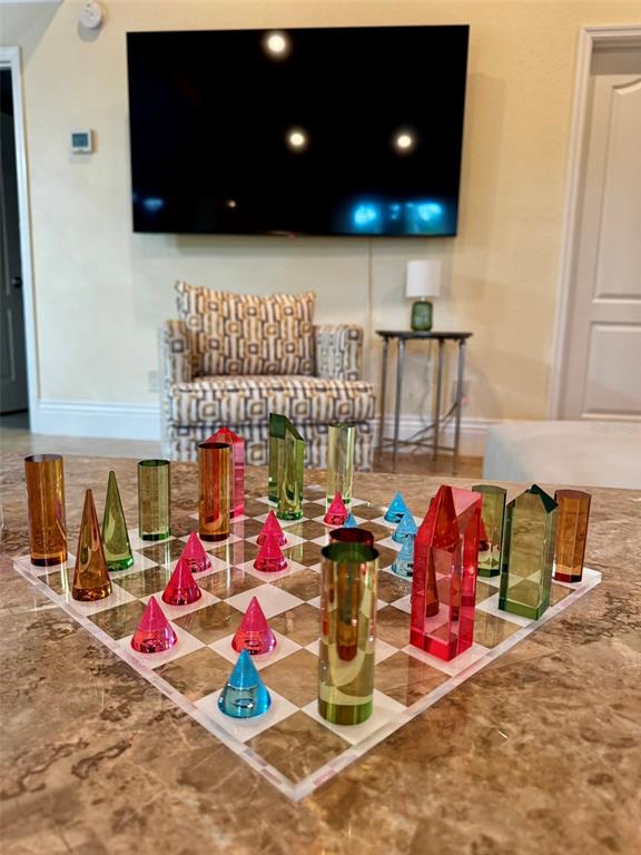 A colorful acrylic chess set sits on a marble countertop in a living room — 4300 GULL COVE, NEW SMYRNA BEACH, FL