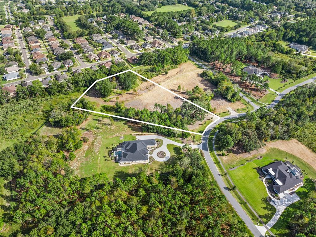 An aerial view shows a vacant, irregularly shaped lot outlined in white near residential homes — 2527 NW 150TH BOULEVARD, NEWBERRY, FL
