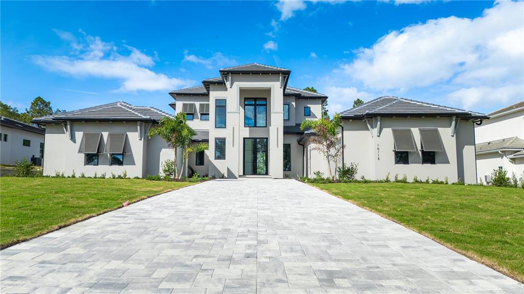 A modern two-story house features a paved driveway, two garages, and a central entryway — 16118 PENDIO DRIVE, MONTVERDE, FL