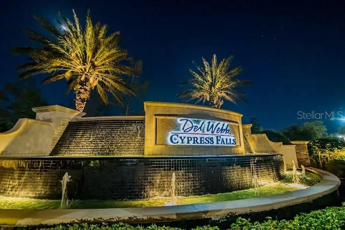 The entrance sign for Del Webb Cypress Falls features a tiered water fountain at night — 2436 ARUGULA DRIVE, NORTH PORT, FL