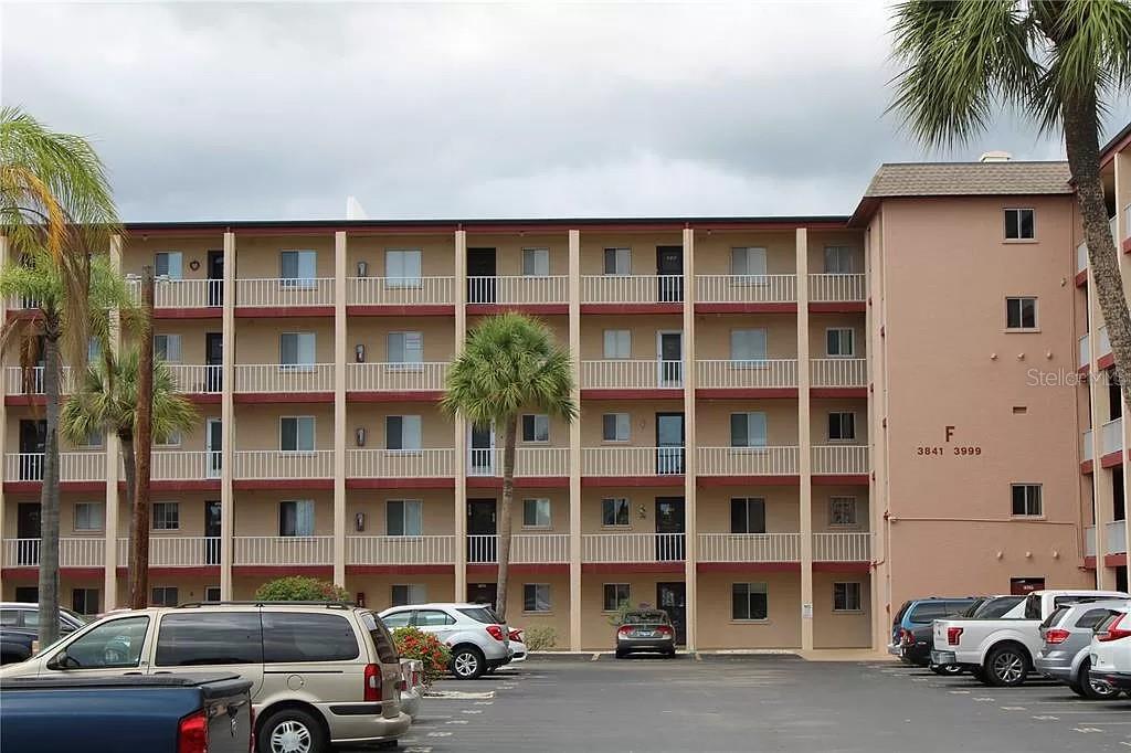 A multi-story apartment building with a parking lot in the foreground — 4242 HERON WAY UNIT B323, BRADENTON, FL