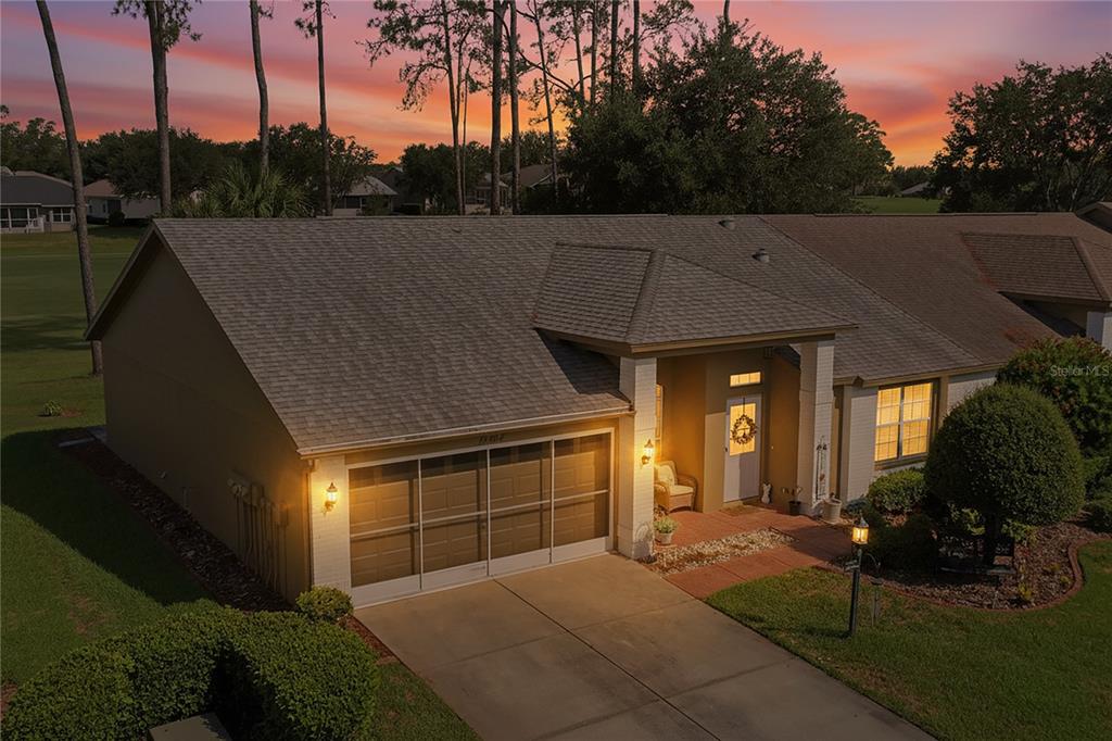 An exterior view of a single-story house with a garage and a brick entryway — 18607 BENT PINE DRIVE, HUDSON, FL