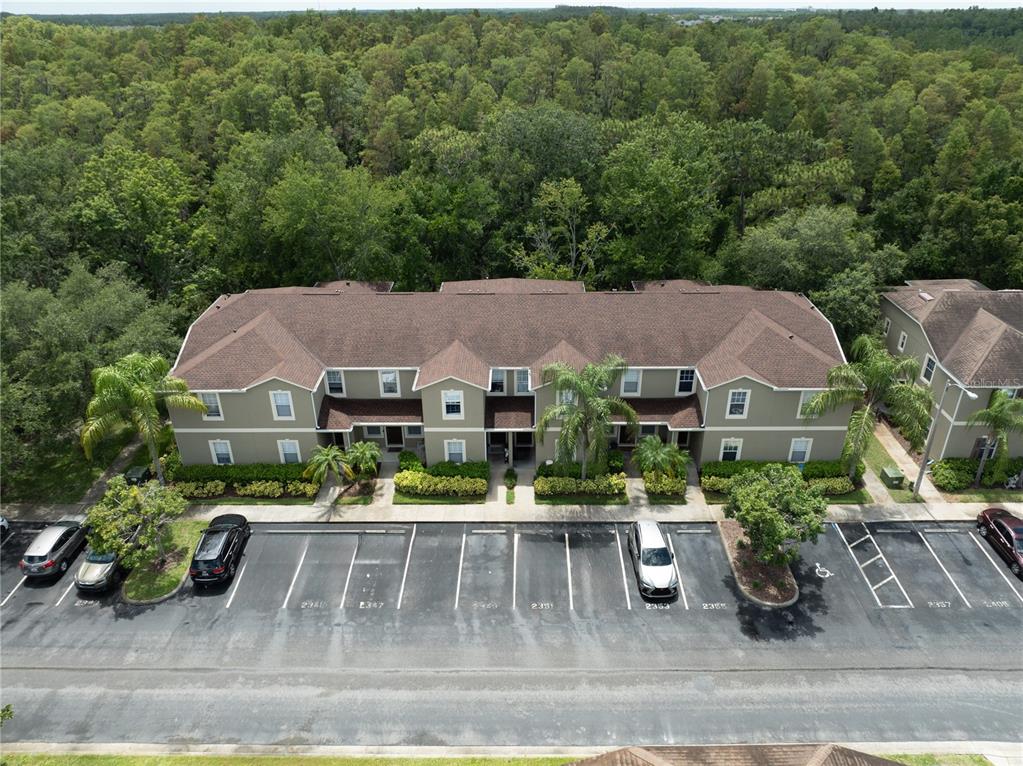 An aerial view shows a two-story apartment building with a parking lot in front — 2349 WILLIMETTE DRIVE, WESLEY CHAPEL, FL