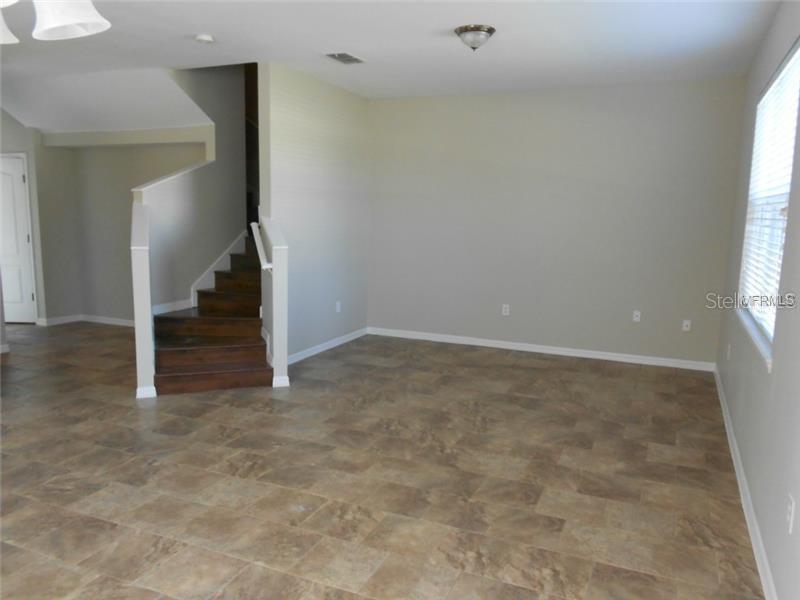 An interior view shows a living area with tile flooring, a staircase, and a window — 3911 PEMBERLY PINES CIRCLE, ST CLOUD, FL