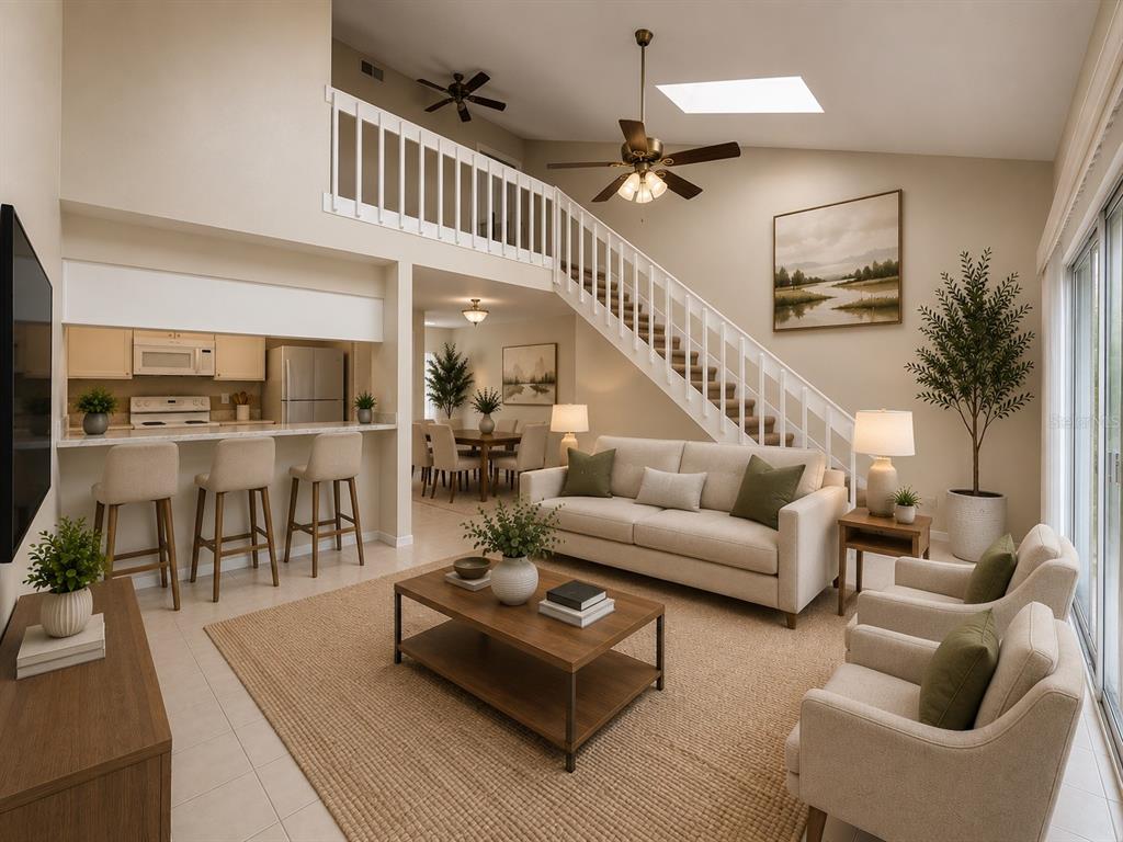 This living room features a vaulted ceiling, a staircase with white railings, and an open kitchen — 2760 GRAY FOX LANE, ORLANDO, FL