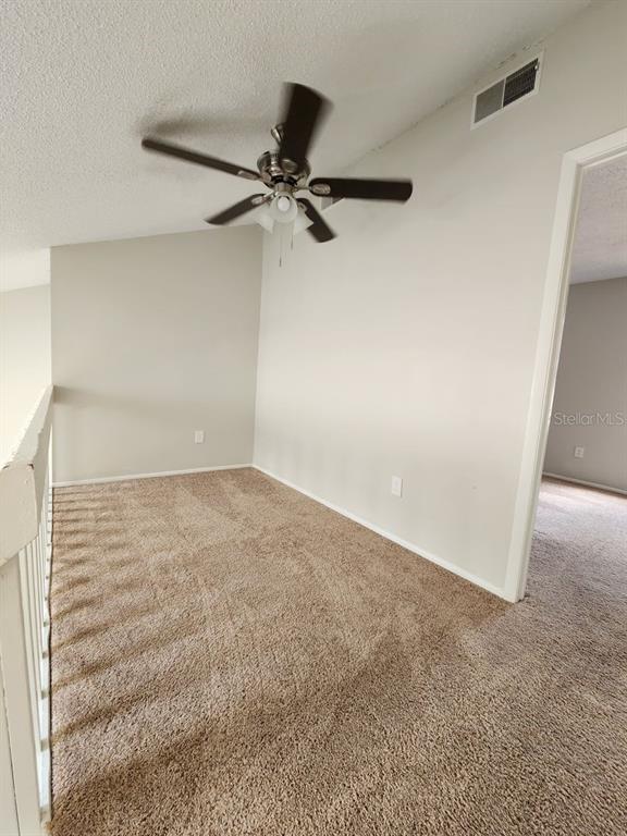An carpeted loft area features a ceiling fan and a white railing overlooking a lower level — 2760 GRAY FOX LANE, ORLANDO, FL