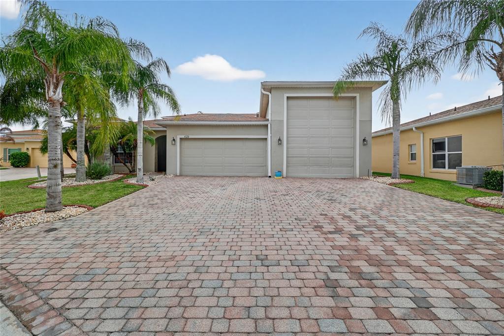 A house exterior features a paver driveway, a two-car garage, and a tall RV garage — 4120 LIMERICK DRIVE, LAKE WALES, FL