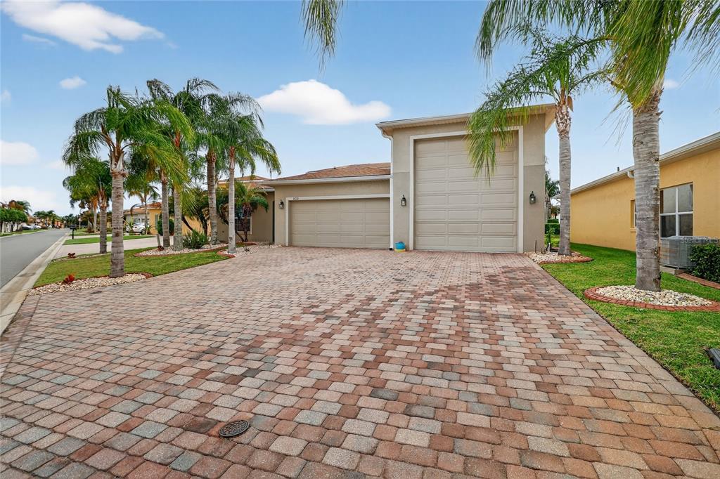 A house exterior featuring a paver driveway, a two-car garage, and a tall RV garage — 4120 LIMERICK DRIVE, LAKE WALES, FL