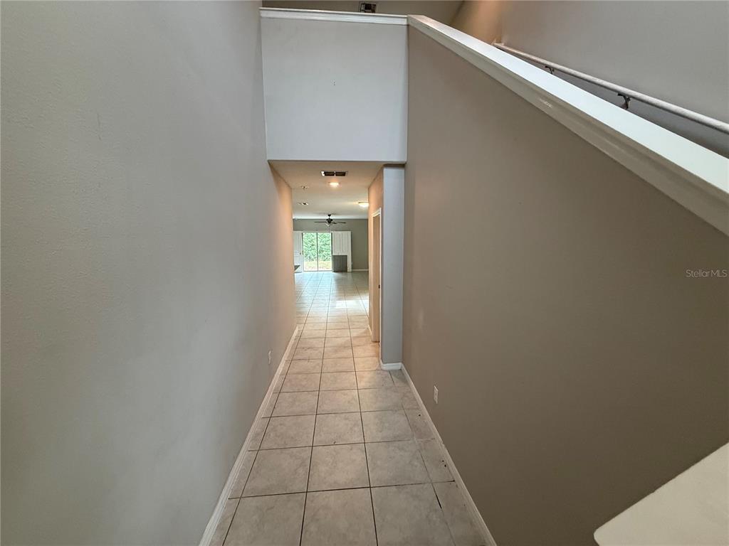 A tiled hallway leads toward an open living area with a sliding glass door — 1752 COLDING DRIVE, RUSKIN, FL
