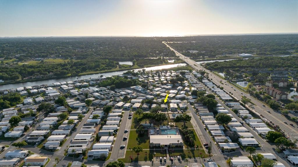An aerial view shows a mobile home community with a pool and a yellow arrow — 372 COBIA WAY, OLDSMAR, FL