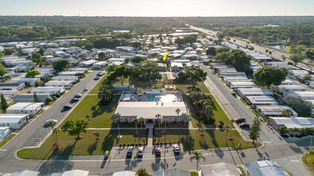 An aerial view shows a mobile home community with a central clubhouse and swimming pool — 372 COBIA WAY, OLDSMAR, FL