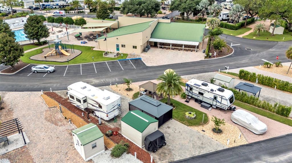 An aerial view shows an RV park with a community building, playground, and parked vehicles — 16414 BAY STREET, CLERMONT, FL